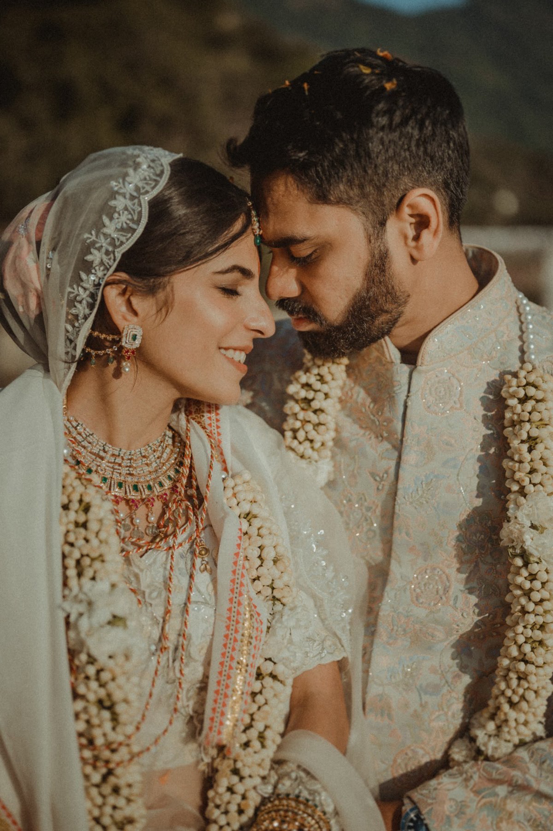 Indian wedding couple in traditional jasmine garlands, photographed by WeddingClickz
