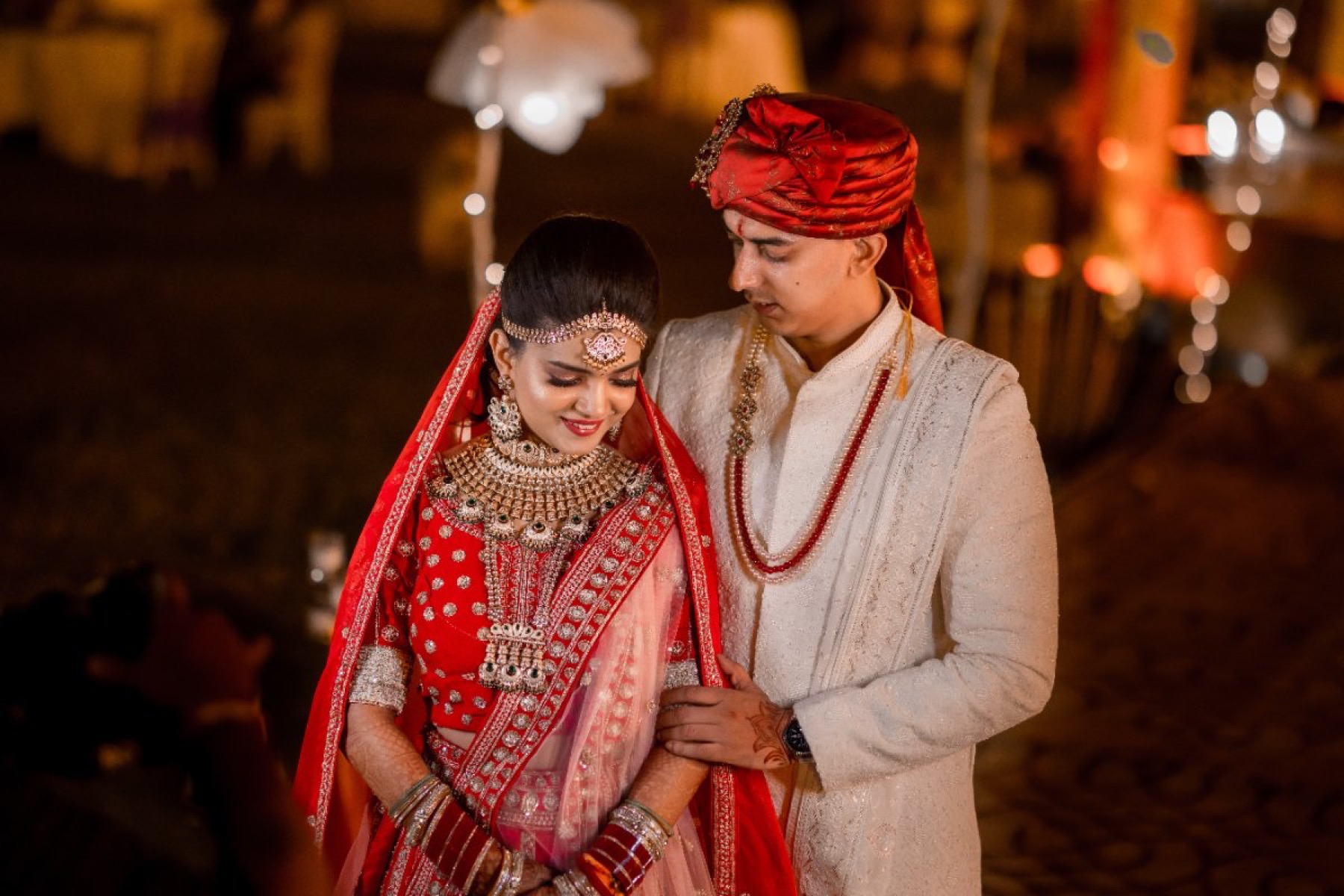 Indian bride and groom in red lehenga and safa, photographed by WeddingClickz
