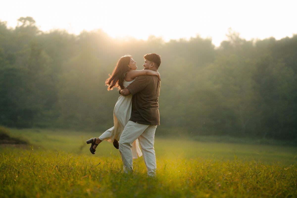 Pre-wedding couple shoot by WeddingClickz — open field, low sun, nothing else in frame